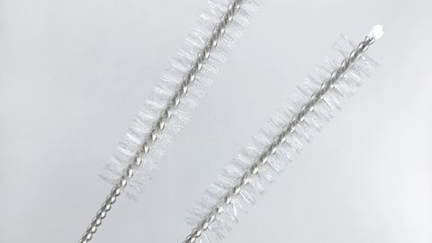 Two nylon straw brushes with twisted wire handles on a white background